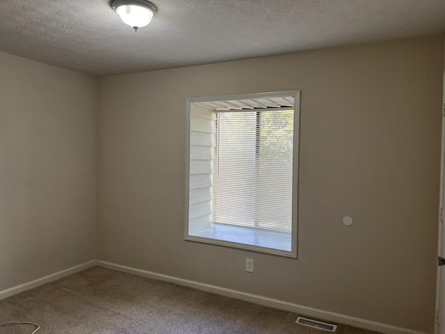 empty room with a textured ceiling and carpet