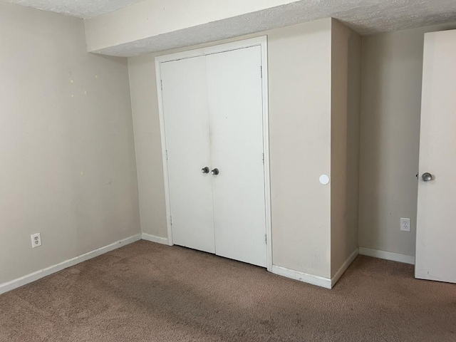 unfurnished bedroom featuring a closet, carpet floors, and a textured ceiling