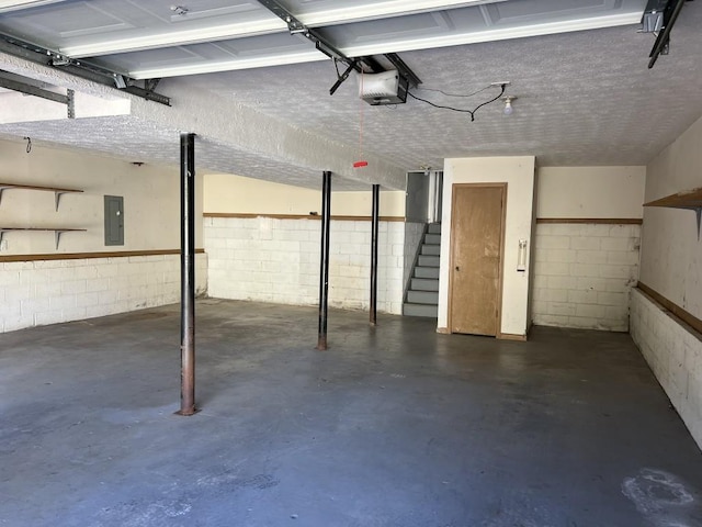 garage with a garage door opener and electric panel