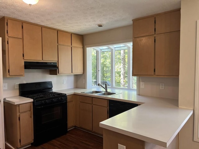 kitchen with sink, black appliances, a textured ceiling, light brown cabinetry, and kitchen peninsula