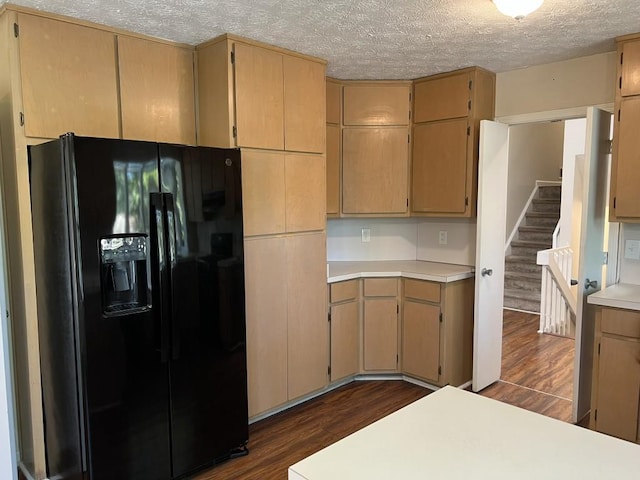 kitchen featuring dark wood-type flooring, light brown cabinetry, black fridge with ice dispenser, and a textured ceiling