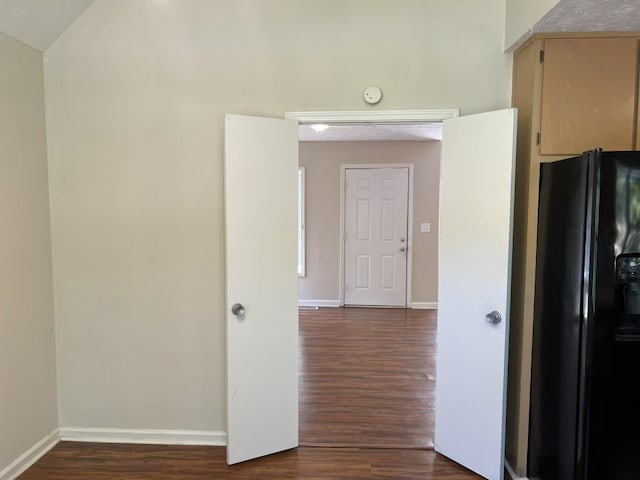 interior space with black fridge and dark wood-type flooring