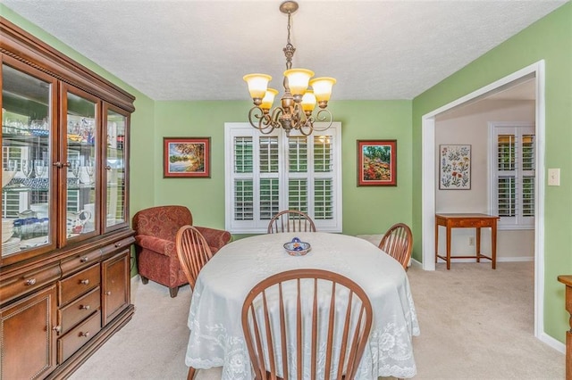 324 Kibbee Rd, Mcdonough, GA 30252 - dining area with light carpet, a chandelier, baseboards, and a textured ceiling