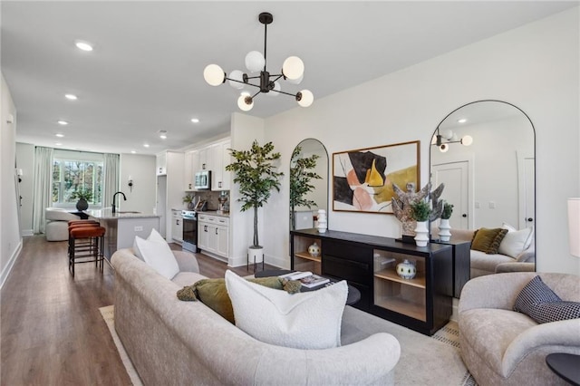 living room featuring a notable chandelier, dark hardwood / wood-style flooring, and sink