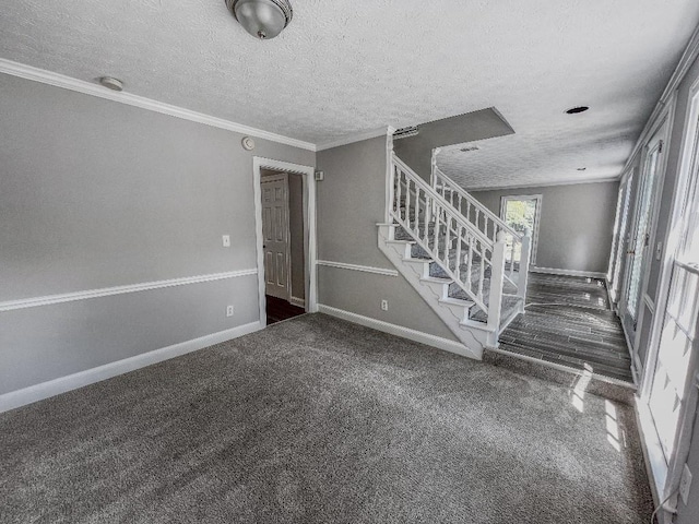 empty room with crown molding, a textured ceiling, and carpet flooring