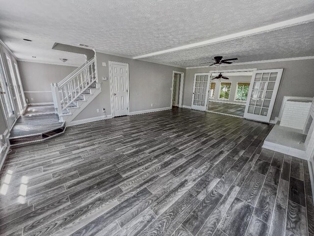 unfurnished living room with dark wood-type flooring, a textured ceiling, and french doors