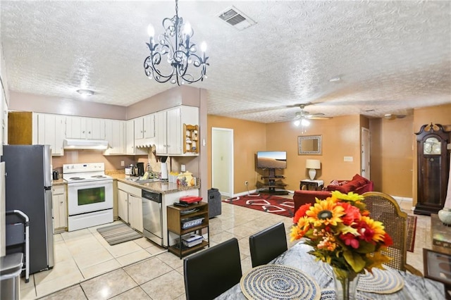 kitchen featuring under cabinet range hood, visible vents, open floor plan, light countertops, and appliances with stainless steel finishes