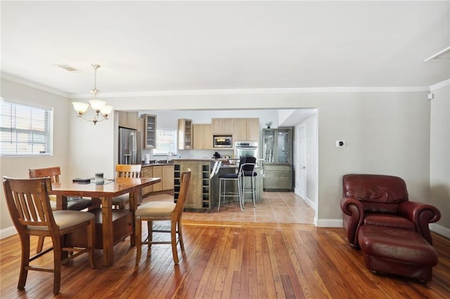 97 Griffin St NW, Atlanta, GA 30314 - dining room featuring light wood finished floors, crown molding, and a chandelier