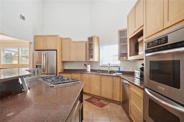 97 Griffin St NW, Atlanta, GA 30314 - kitchen with appliances with stainless steel finishes, a high ceiling, light brown cabinets, and healthy amount of natural light