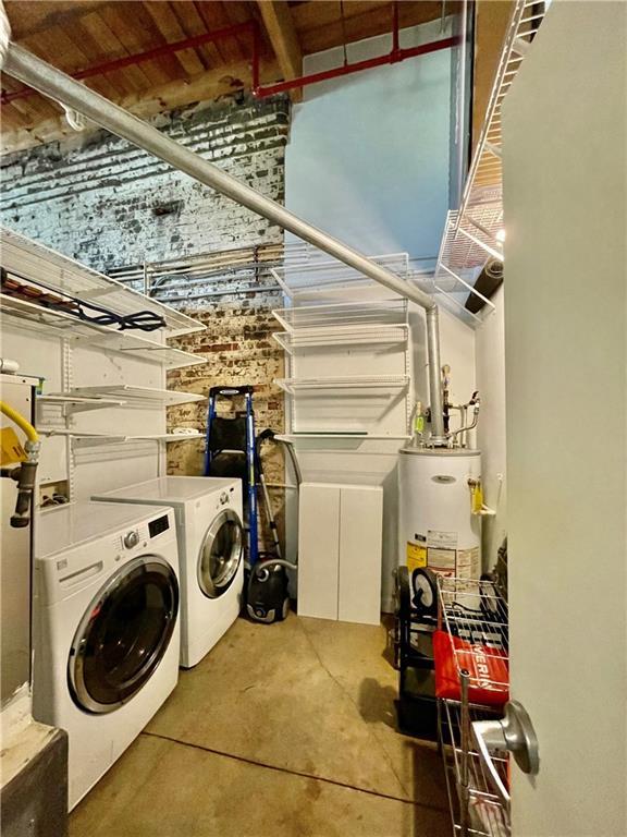 laundry room featuring water heater, laundry area, and independent washer and dryer