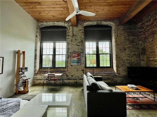sitting room with brick wall, wood ceiling, a ceiling fan, and beam ceiling