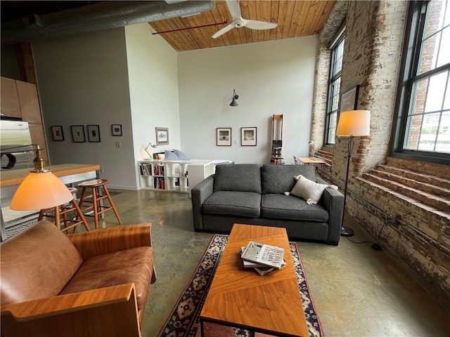 living room with a ceiling fan, concrete floors, wood ceiling, and high vaulted ceiling