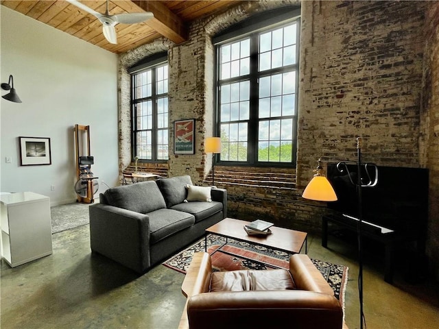 sitting room with wood ceiling, ceiling fan, a towering ceiling, finished concrete flooring, and beam ceiling