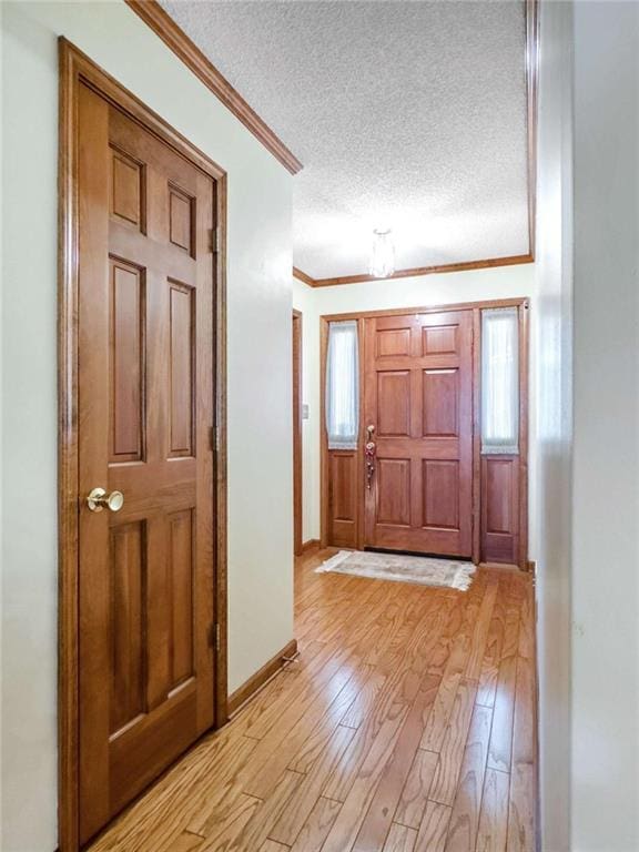 foyer entrance featuring plenty of natural light, a textured ceiling, and light hardwood / wood-style flooring