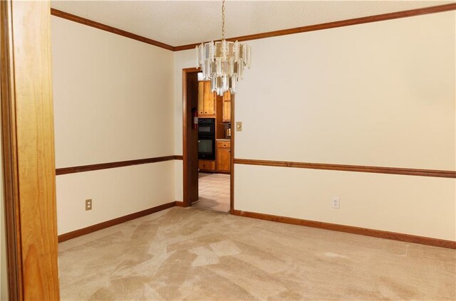 unfurnished room featuring baseboards, ornamental molding, a notable chandelier, and light colored carpet