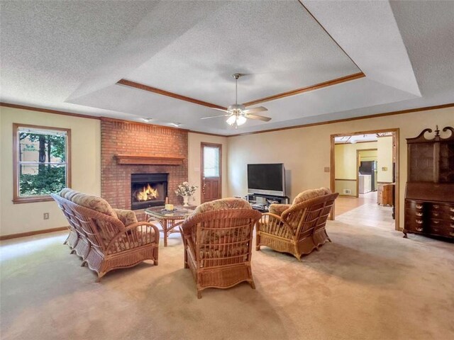 interior space with a raised ceiling, ceiling fan, a brick fireplace, and light carpet