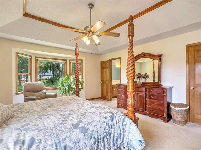 bedroom with a tray ceiling, a ceiling fan, and light colored carpet