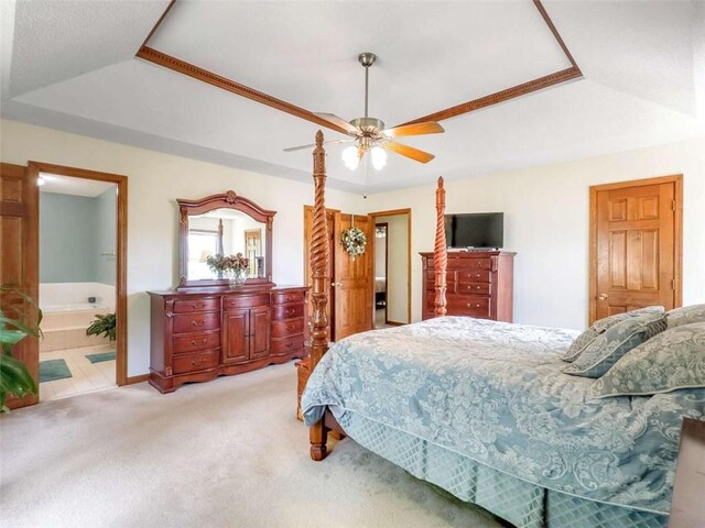 bedroom featuring carpet floors, connected bathroom, ceiling fan, and a raised ceiling