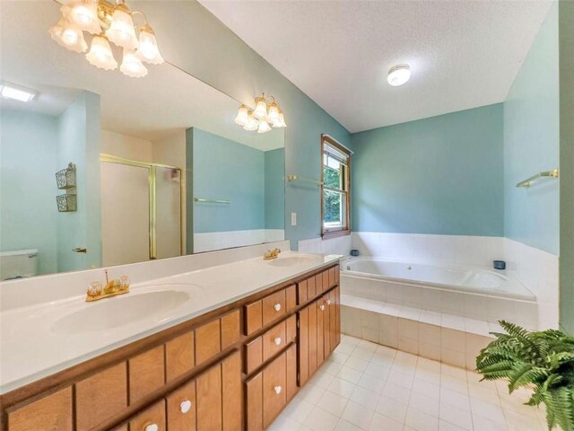 bathroom featuring a textured ceiling, a bath, a sink, and an inviting chandelier