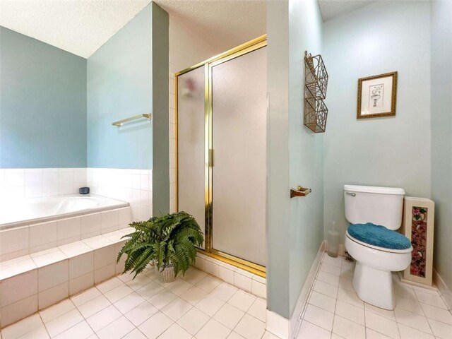 full bath featuring tile patterned flooring, toilet, a textured ceiling, a shower stall, and a garden tub