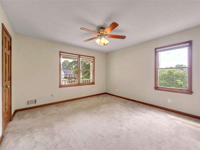 bedroom with a textured ceiling, ceiling fan, and light colored carpet