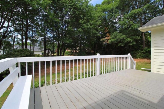 rear view of house with a wooden deck and a yard