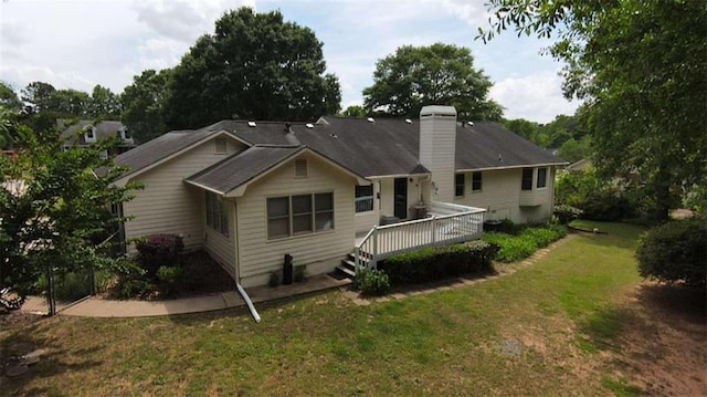 back of house with a deck and a lawn