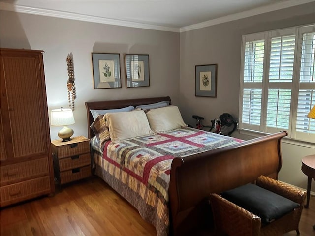 bedroom with light wood-type flooring and ornamental molding