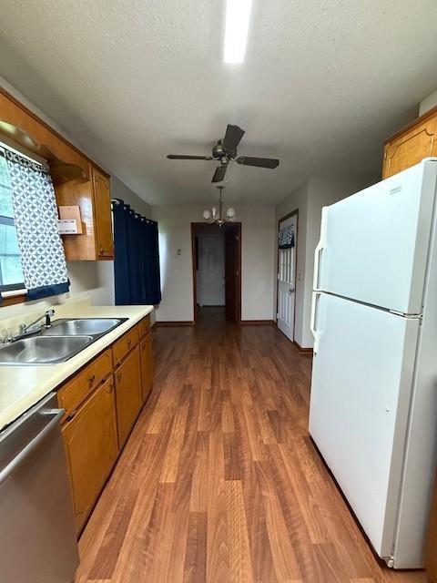 100 Walter Leon Dr, Chatsworth, GA 30705 - kitchen featuring freestanding refrigerator, stainless steel dishwasher, brown cabinets, light countertops, and light wood finished floors