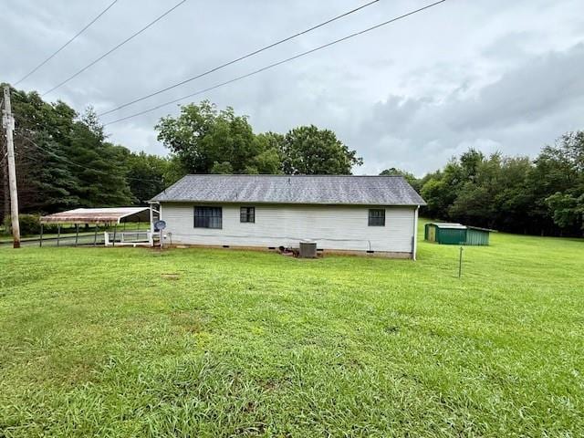 100 Walter Leon Dr, Chatsworth, GA 30705 - back of house with a detached carport, a lawn, crawl space, and an outdoor structure