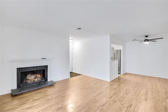 unfurnished living room featuring light hardwood / wood-style flooring and ceiling fan