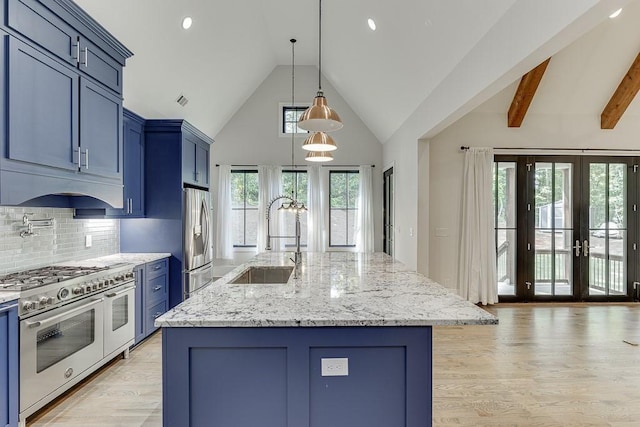 kitchen with light stone counters, blue cabinetry, stainless steel appliances, light wood-style flooring, and a sink