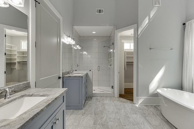 bathroom featuring a stall shower, visible vents, a sink, and a spacious closet