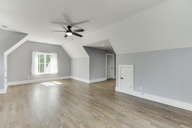 additional living space with a ceiling fan, baseboards, vaulted ceiling, and wood finished floors