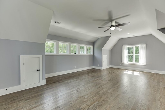 additional living space featuring lofted ceiling, visible vents, baseboards, and wood finished floors