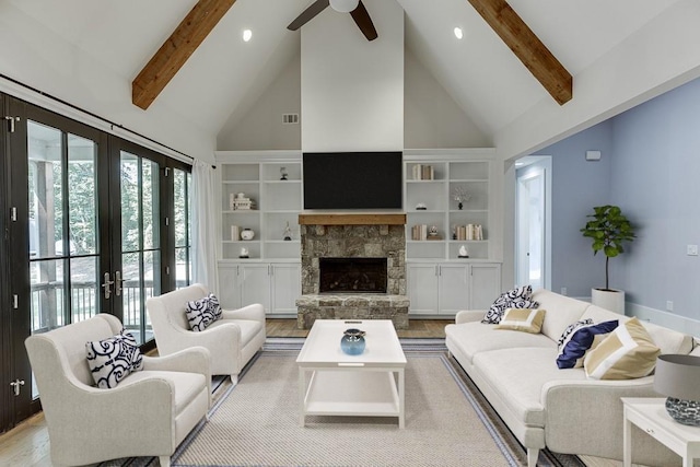 living area with high vaulted ceiling, a fireplace, visible vents, light wood-type flooring, and beam ceiling