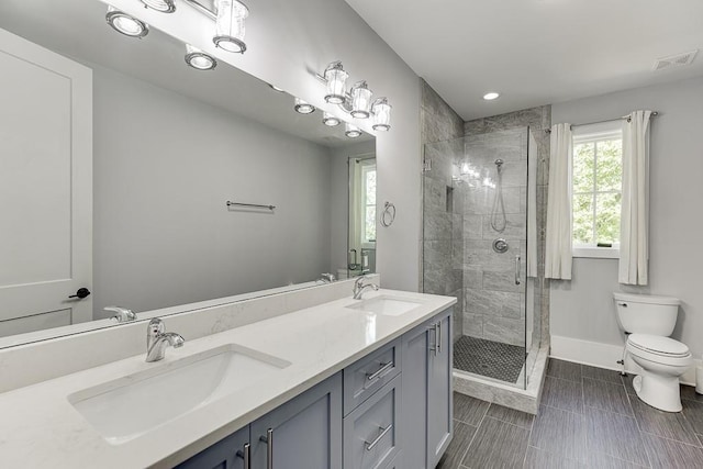 bathroom with toilet, a shower stall, baseboards, and a sink