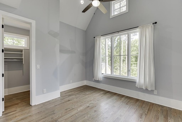 empty room with a wealth of natural light, baseboards, and wood finished floors