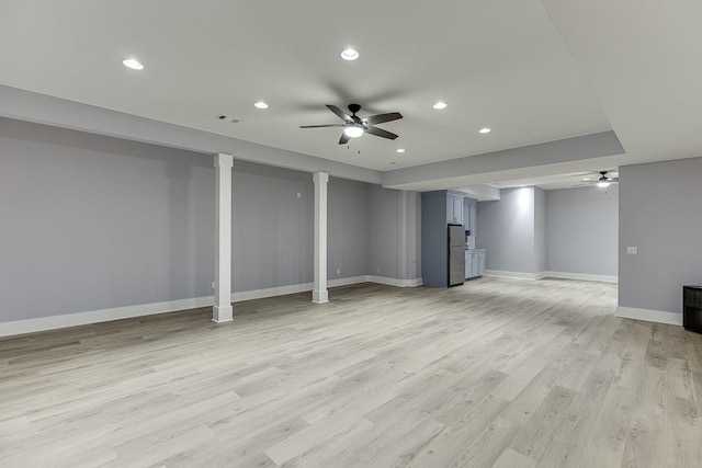 finished basement featuring recessed lighting, visible vents, freestanding refrigerator, light wood-type flooring, and baseboards