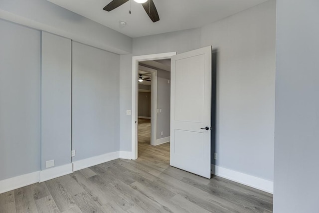 unfurnished bedroom with ceiling fan, light wood-style flooring, and baseboards