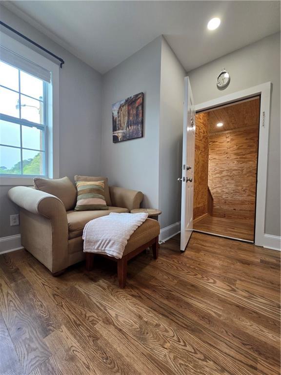 living area with baseboards and wood finished floors