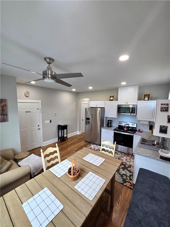 dining room with wood finished floors, a ceiling fan, and recessed lighting