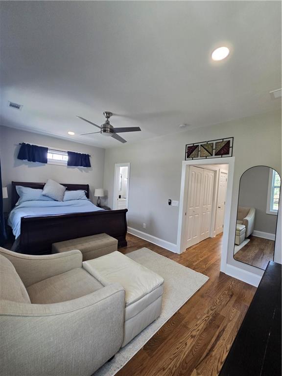 bedroom with arched walkways, recessed lighting, visible vents, dark wood-type flooring, and baseboards