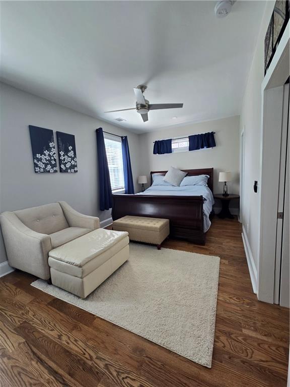 bedroom featuring dark wood-style flooring, ceiling fan, and baseboards