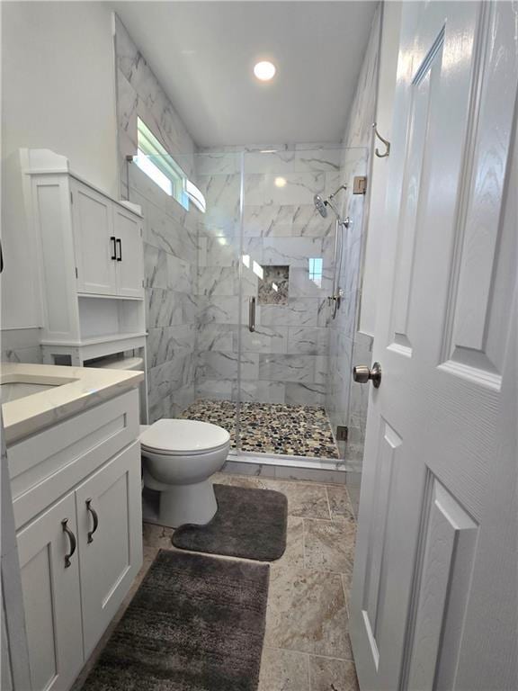 full bath with toilet, a marble finish shower, and vanity