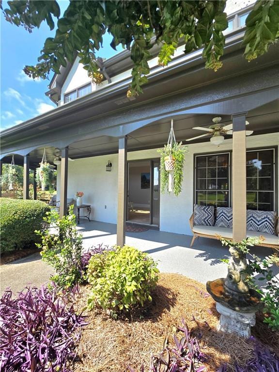 view of exterior entry with ceiling fan