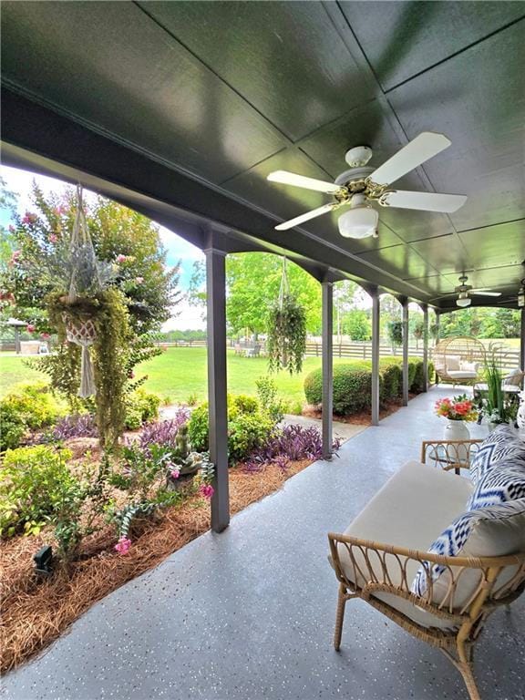 view of patio with fence and a ceiling fan