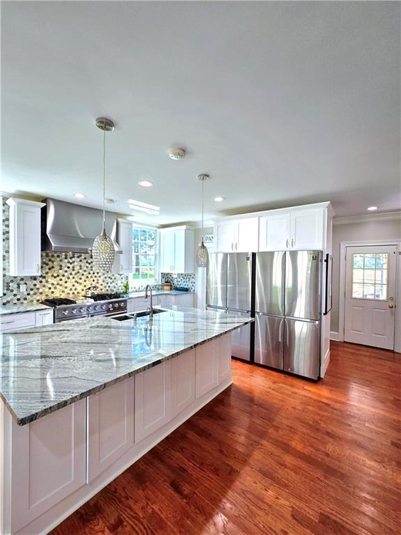 kitchen featuring plenty of natural light, white cabinets, pendant lighting, and sink