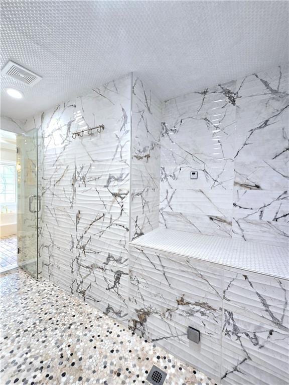 room details with a textured ceiling and tiled shower