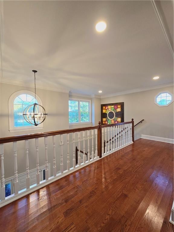 interior space featuring ornamental molding, a wealth of natural light, wood finished floors, and an inviting chandelier